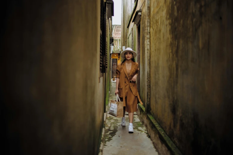 a woman walking down a narrow alley way, by Han Gan, pexels contest winner, caracter with brown hat, wearing a simple robe, cardboard, woman posing