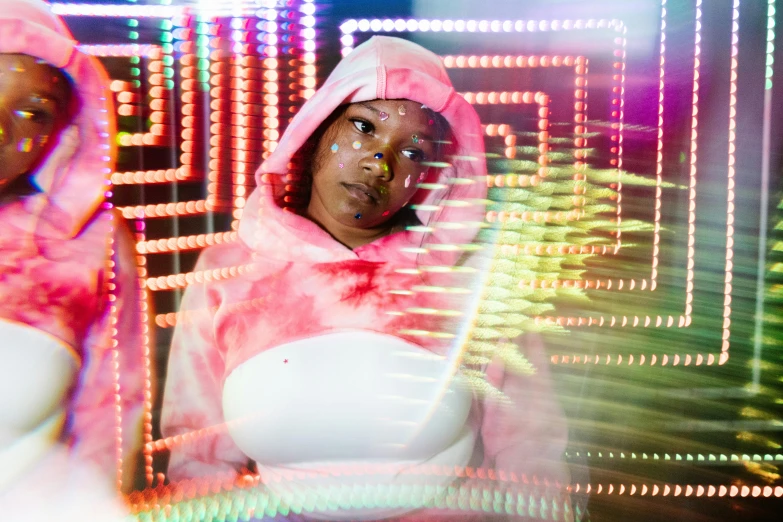 a couple of women standing next to each other, a portrait, inspired by David LaChapelle, unsplash, afrofuturism, wearing a pink hoodie, skin made of led point lights, woman in a sheep costume, lizzo