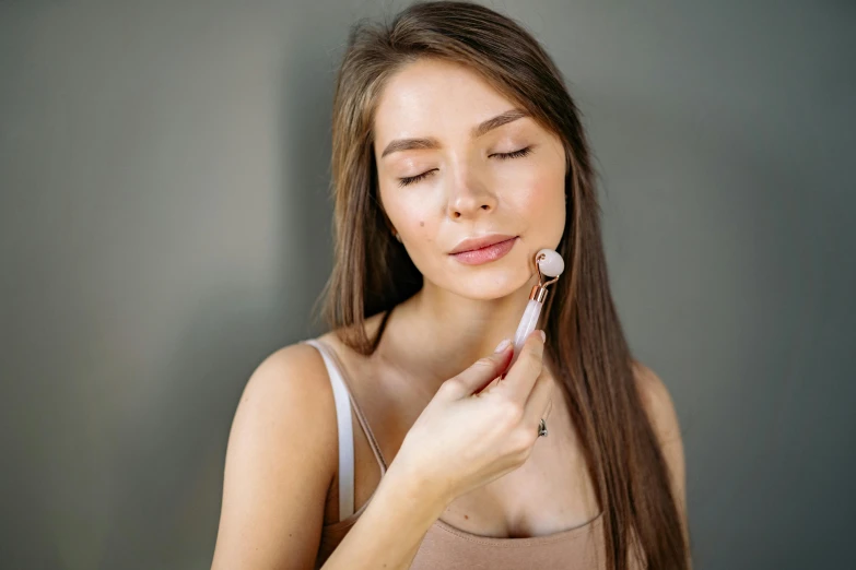 a woman brushing her teeth with an electric toothbrush, by Julia Pishtar, trending on pexels, art nouveau, round jawline, brunette, manuka, candy treatments