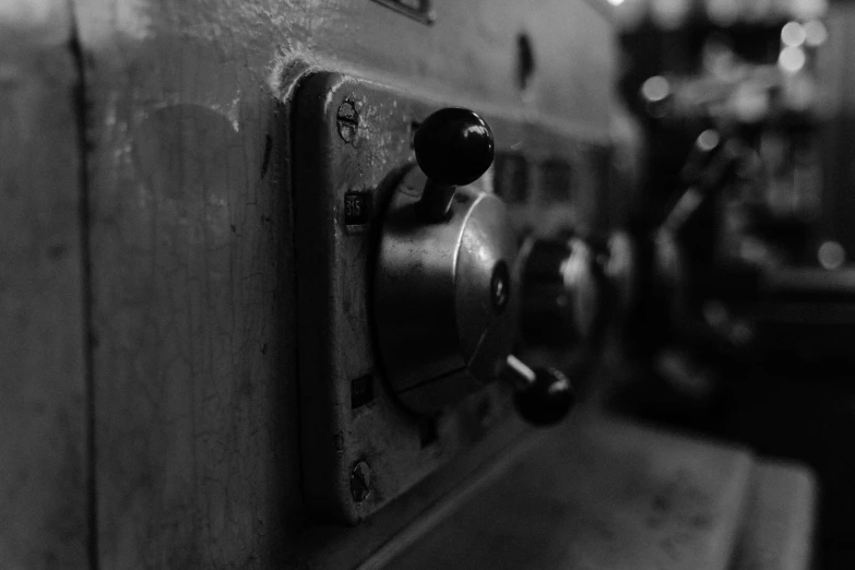 a black and white photo of a door handle, by Karl Buesgen, unsplash, les automatistes, working inside reactor room, old experimentation cabinet, controller, closeup photograph