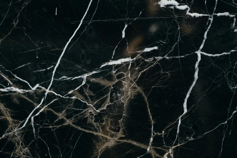 a close up of a black marble surface, an album cover, trending on pexels, abstract expressionism, wires and veins, 8k high quality, ignant, unsplash 4k