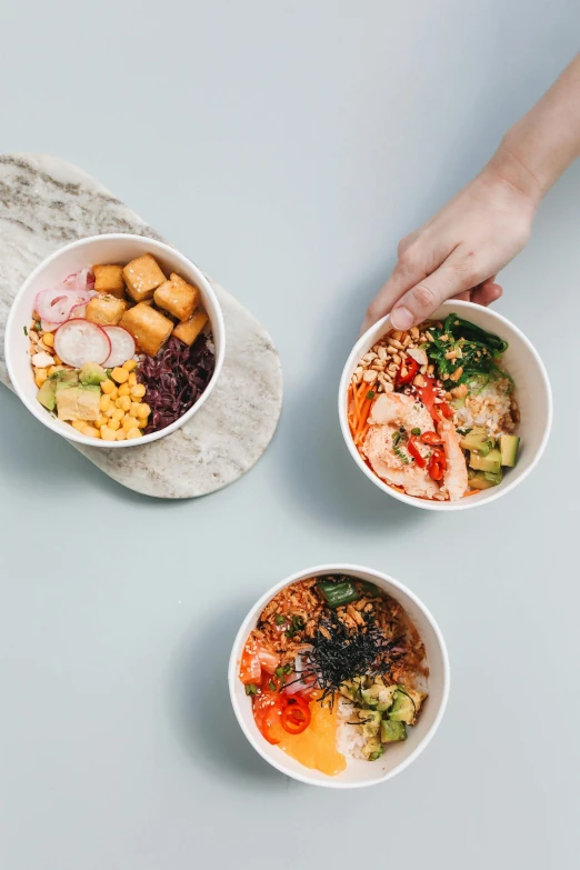 three bowls of food sitting on top of a table, sleek hands, square, order, taejune kim