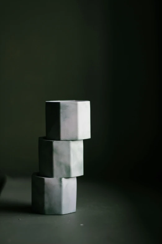a stack of cubes sitting on top of a table, inspired by Robert Mapplethorpe, unsplash, concrete art, vessels, cake sculpture, dwell, three quarter angle