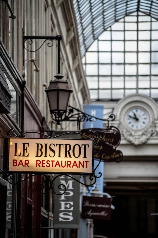 a restaurant sign hanging from the side of a building, inspired by Brassaï, art nouveau, prefecture streets, high light on the left, bastion, inside a bar