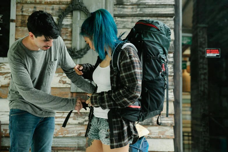 a couple of people standing next to each other, trending on pexels, backpack, with blue hair, scene from a movie, high elevation