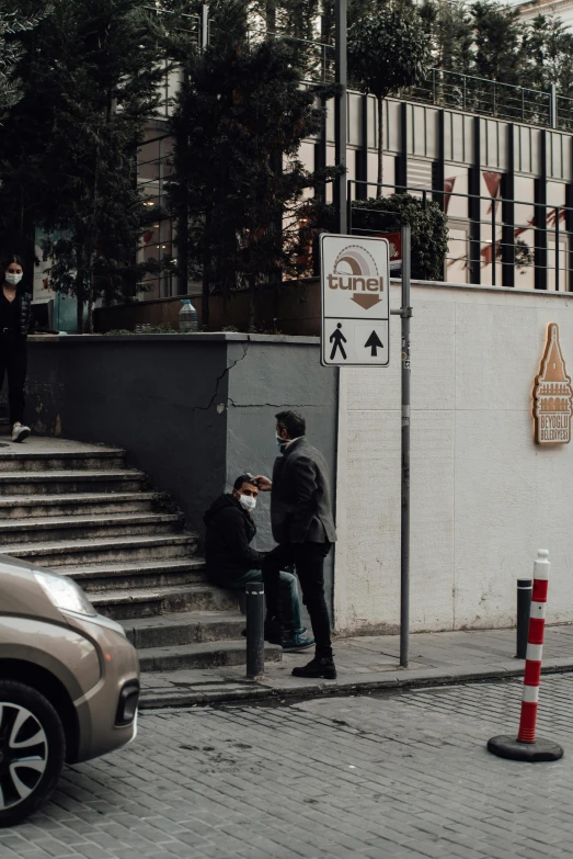 a car is parked on the side of the street, by Niko Henrichon, pexels contest winner, outdoor staircase, people are wearing masks, hidden message, two people