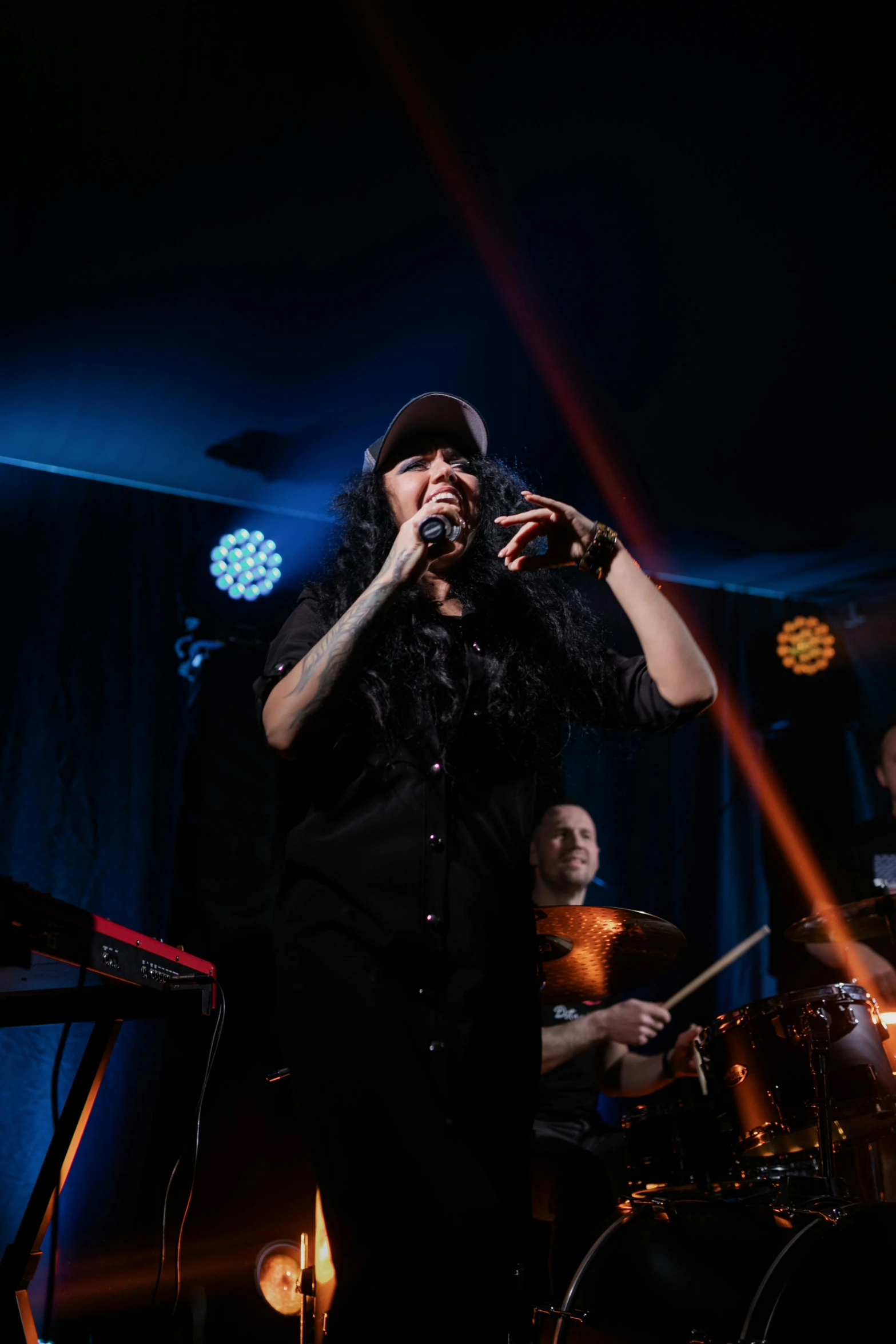 a group of people standing on top of a stage, an album cover, pexels, alanis guillen, singing into microphone, jazz, smokey room