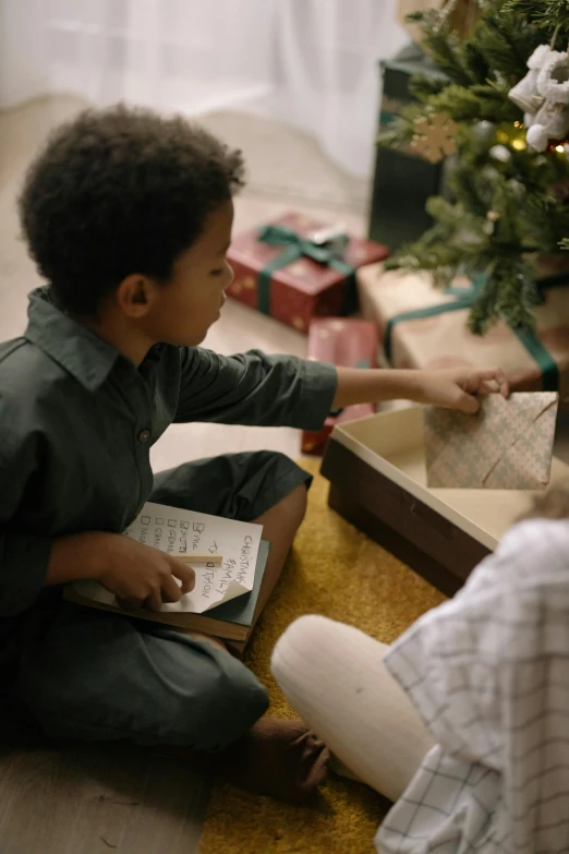 a couple of kids sitting on the floor near a christmas tree, pexels contest winner, visual art, holding spell book, gif, shot from cinematic, holding gift