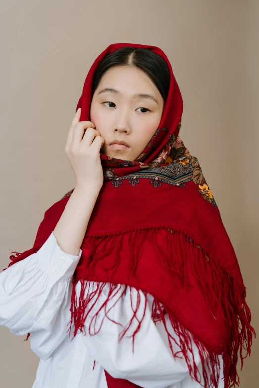 a woman in a red shawl talking on a cell phone, inspired by Kim Tschang Yeul, trending on pexels, renaissance, made of wool, portrait of a japanese teen, muslim, outfit photograph