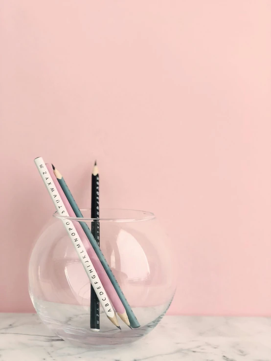 a glass bowl filled with pencils and a ruler, by Emma Geary, postminimalism, ((pink)), professional product photo, tall thin, ilustration