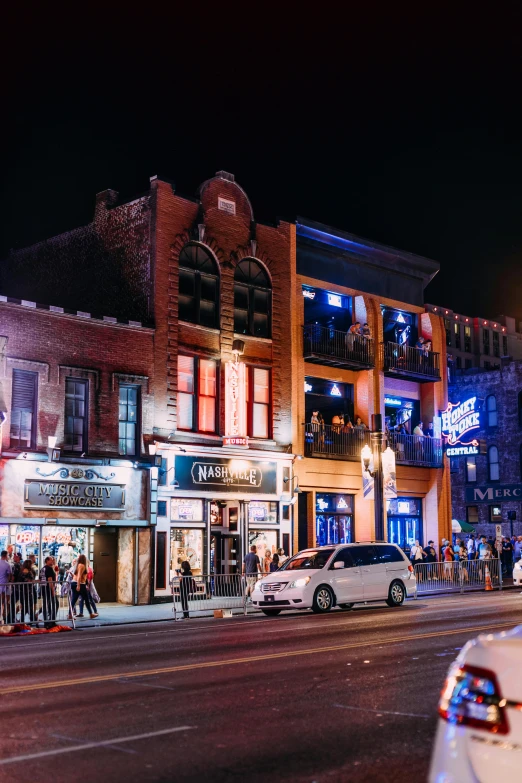 a police car parked on the side of a street, by Drew Tucker, trending on unsplash, renaissance, dive bar with a karaoke machine, all buildings on bridge, old west town, people at night