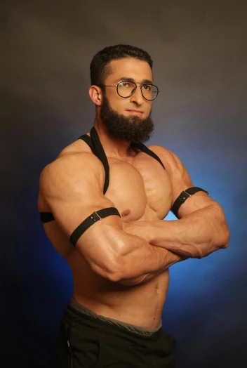 a man with a beard and glasses posing for a picture, an album cover, inspired by Amir Zand, featured on reddit, dau-al-set, muscular!!!, black leather harness, muslim, muscular!