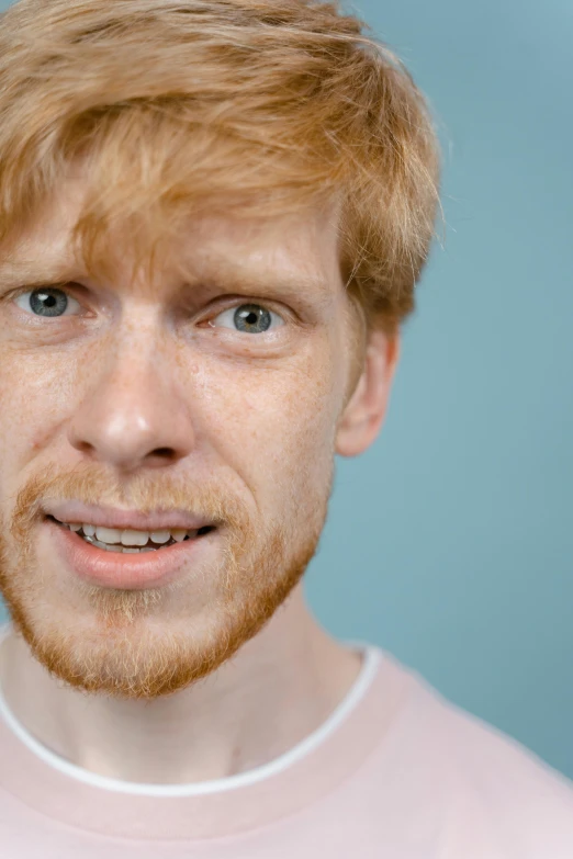 a close up of a person wearing a pink shirt, reddit, renaissance, looks like domhnall gleeson, ginger hair with freckles, shot with sony alpha 1 camera, solid background