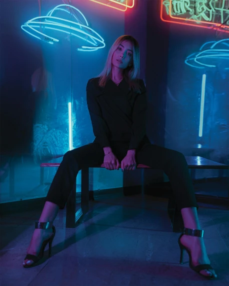 a woman sitting on a bench in front of neon signs, pexels contest winner, wearing black modern clothes, standing in a dimly lit room, sydney sweeney, teal lights