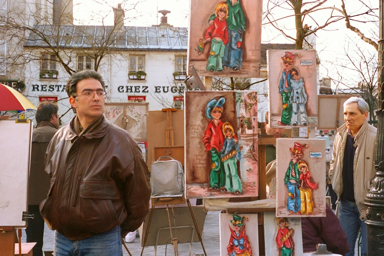 a man standing in front of a bunch of paintings, inspired by Maurice Utrillo, serial art, vendors, filmstill, square, brown