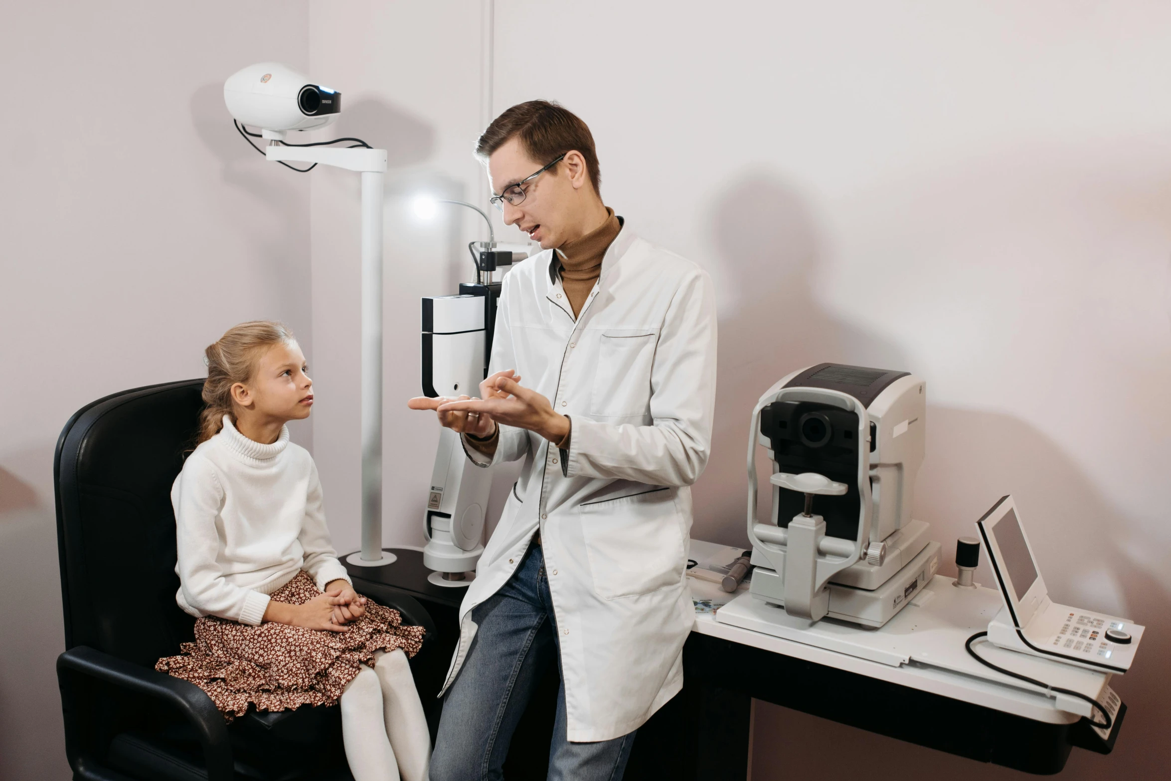 a man standing next to a little girl in a chair, by Adam Marczyński, pexels contest winner, wearing lab coat and glasses, robotic eye, doctors office, neo kyiv