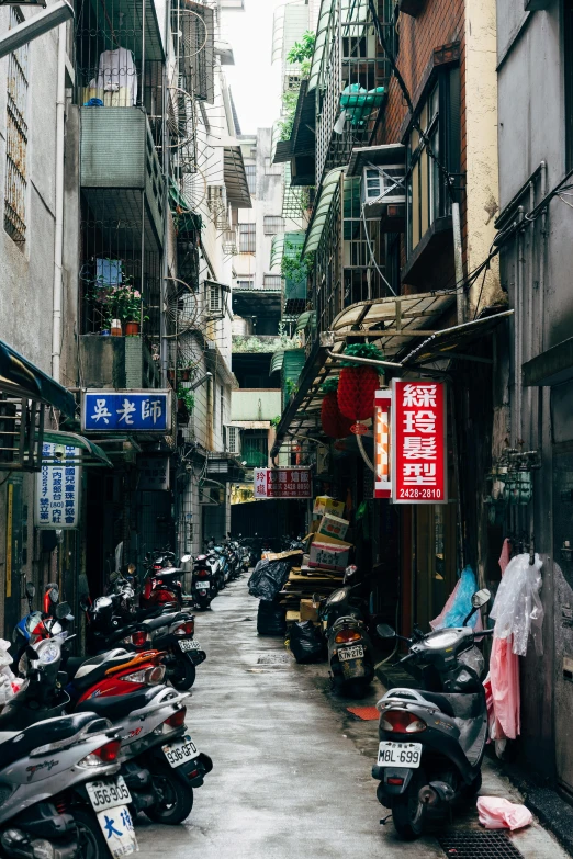 a row of motor scooters parked in a narrow alley, by Daniel Lieske, pexels contest winner, like jiufen, buildings covered with greebles, panoramic shot, wet market street