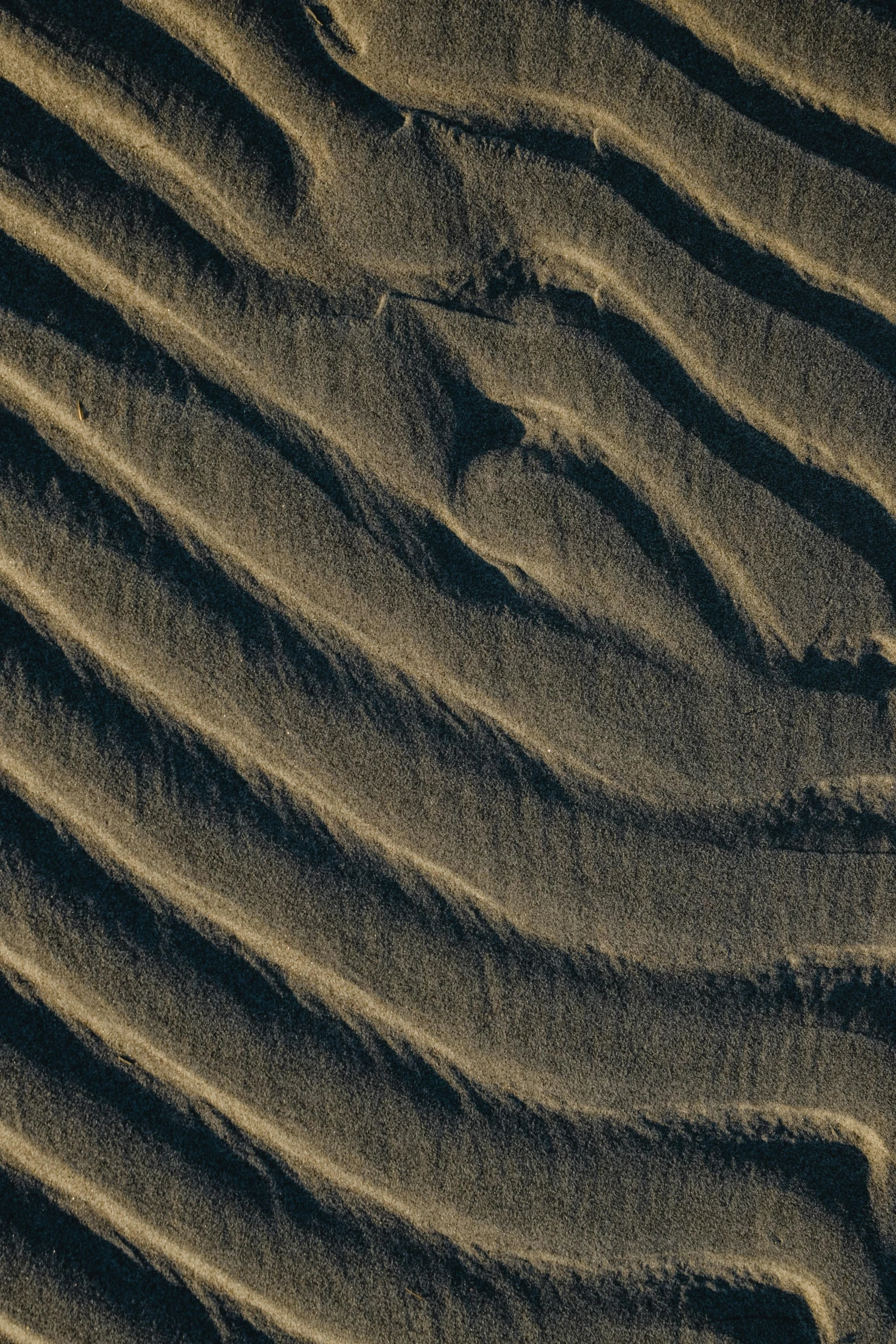 a close up of sand on a beach, by Peter Churcher, unsplash contest winner, conceptual art, swirly lunar ripples, dark hues, desert dunes, fine structure texture