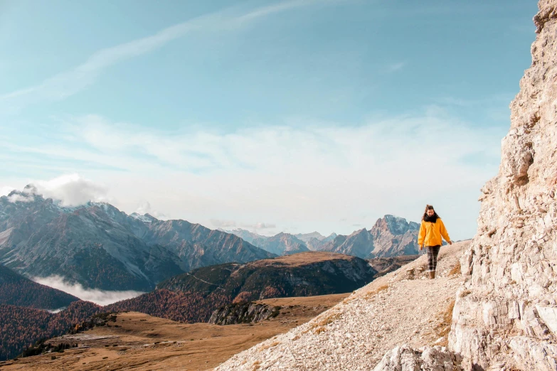 a person standing on top of a mountain, by Emma Andijewska, pexels contest winner, italy, autumn mountains, walking to the right, various posed