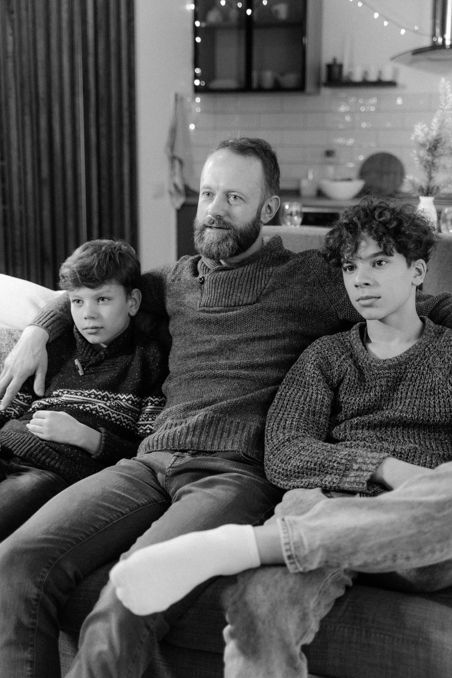 a black and white photo of a family sitting on a couch, by Jaakko Mattila, pexels, hyperrealism, lgbtq, paul giamatti, adrian tomine, holiday