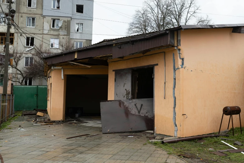 a building with a fire hydrant in front of it, by Adam Marczyński, shutterstock, scrap metal on workbenches, war in ukraine, car garage, 15081959 21121991 01012000 4k