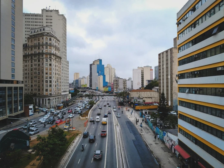 a city street filled with lots of traffic next to tall buildings, a photo, by Ceferí Olivé, pexels contest winner, hyperrealism, brazilian, houses and roads, brutalism buildings, 2000s photo
