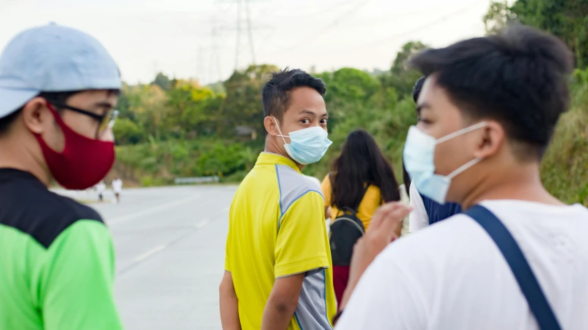 a group of people standing next to each other on a road, pexels contest winner, happening, medical mask, asian male, profile image, wearing hi vis clothing