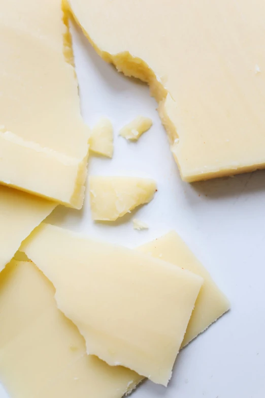 a white plate topped with slices of cheese, (12x) extremely pale white skin, promo image, high - key, crushed quality