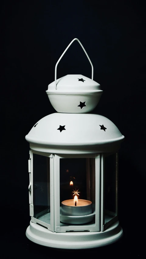 a white lantern with a lit candle inside of it, by Julian Allen, pexels, tiny stars, angled shot, low detail, glossy white metal