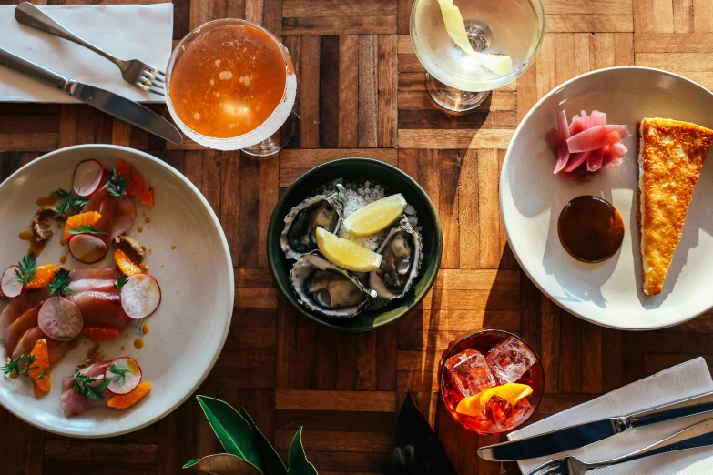 a wooden table topped with plates of food, unsplash, renaissance, saltwater, straya, drink, conde nast traveler photo