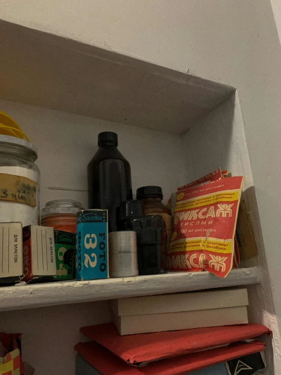 a book shelf filled with lots of books, hyperrealism, bottles of spices, low quality instant camera photo, mid-shot of a hunky, product