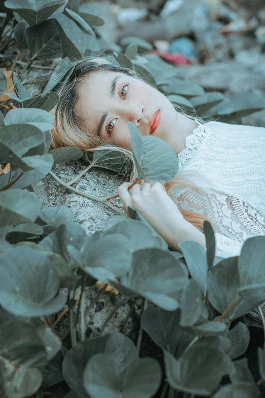 a woman laying on top of a lush green field, inspired by Elsa Bleda, pexels contest winner, aestheticism, with ivy, kiko mizuhara, high angle closeup portrait, made of leaves