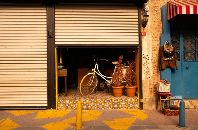 a bicycle is parked in front of a garage, pexels contest winner, graffiti, in barcelona, yellow awning, brown, exiting store