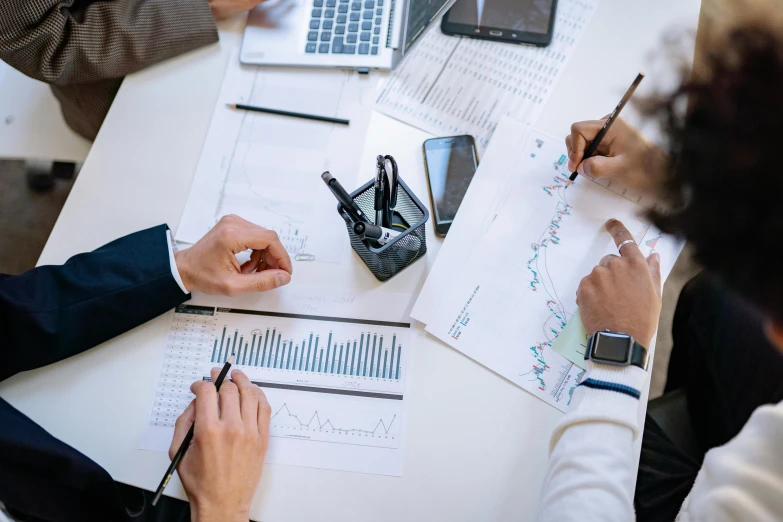 a group of people sitting at a table with laptops, trending on pexels, analytical art, graphs, avatar image, closeup - view, professional image