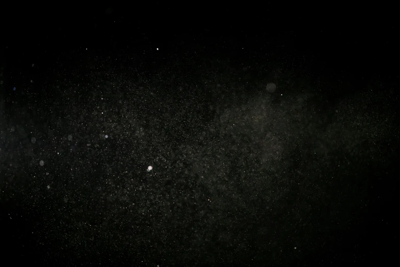 a man riding a snowboard down a snow covered slope, a microscopic photo, by Adam Pijnacker, light and space, black sky full of stars, background image, covered in dust, night photo