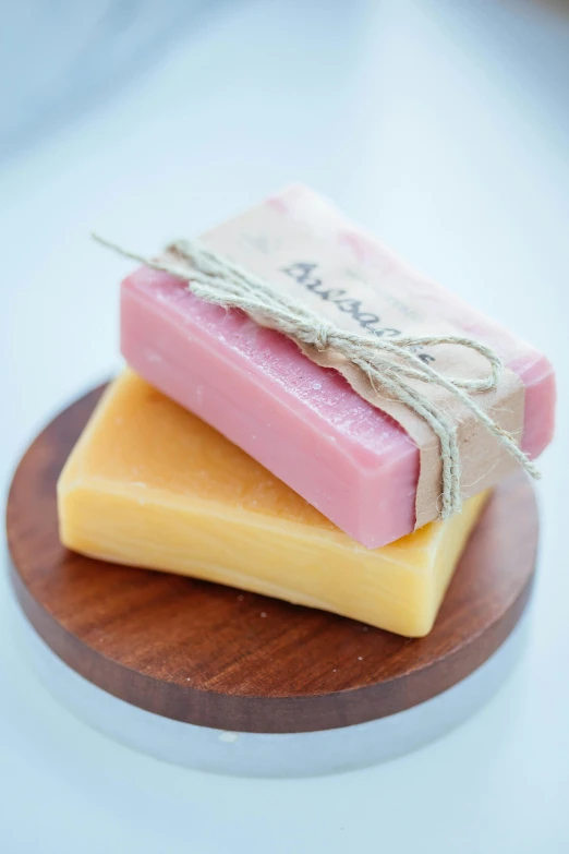 three soap bars stacked on top of each other, by Jessie Algie, on a wooden tray, pink and yellow, avalon, hispanic