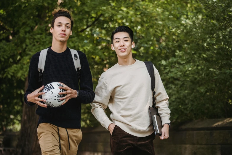 two young men standing next to each other holding a soccer ball, by Marshall Arisman, pexels, renaissance, ethnicity : japanese, with a backpack, 15081959 21121991 01012000 4k, edmund blair and charlie bowater