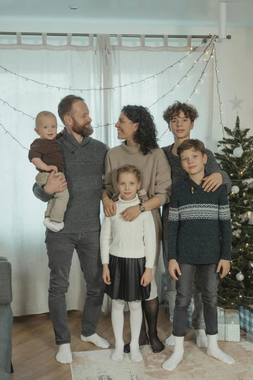 a family posing for a picture in front of a christmas tree, by Kristian Zahrtmann, low quality video, alessio albi, genderless, blank