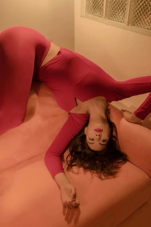 a woman laying on top of a pink couch, inspired by Ren Hang, trending on pexels, arabesque, in spandex suit, bending over, red, full pov