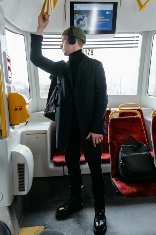 a man that is standing in a bus, bang olufsen, full body camera shot, julian ope, train far