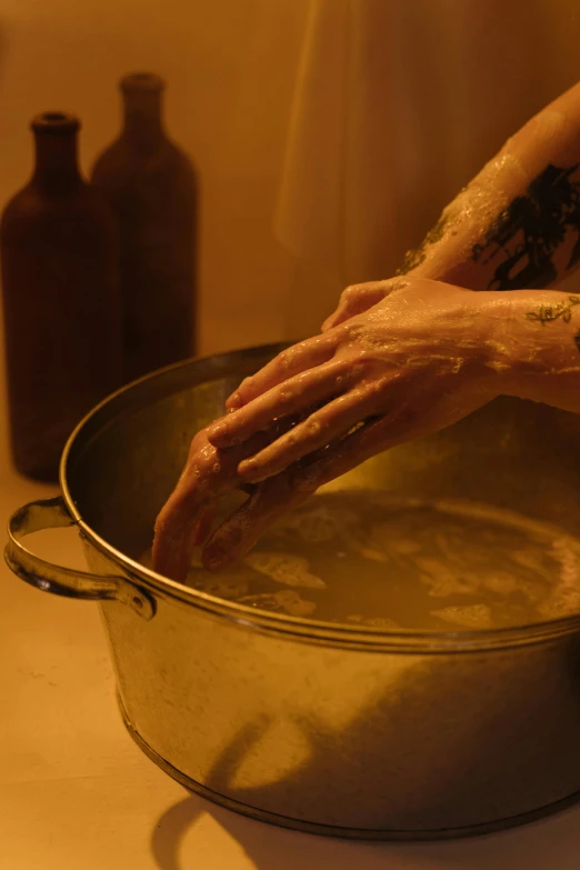 a close up of a person's hand in a pot of food, inspired by Elsa Bleda, process art, bathing in light, apothecary, in a darkly lit laboratory room, cast