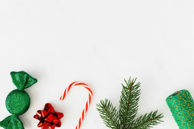 a couple of candy canes sitting on top of a table, trending on pexels, minimalism, evergreen branches, background image, various items, ad image