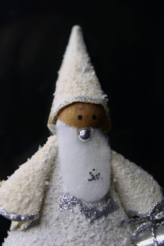 a close up of a figurine of a santa claus, inspired by Ernest William Christmas, process art, white and silver, soft and fluffy, cone shaped, hooded