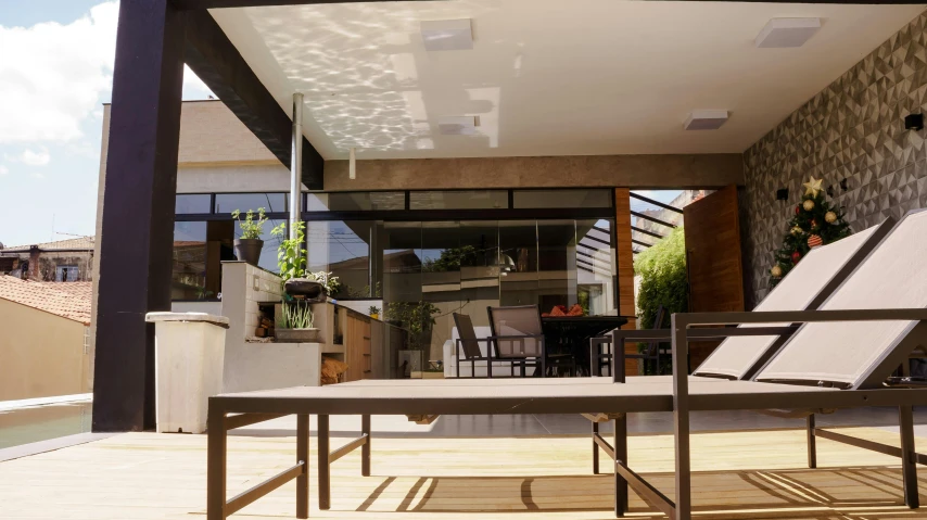 a couple of chairs sitting on top of a wooden deck, a digital rendering, unsplash, light and space, eichler home, skylights, 3/4 view from below, awnings