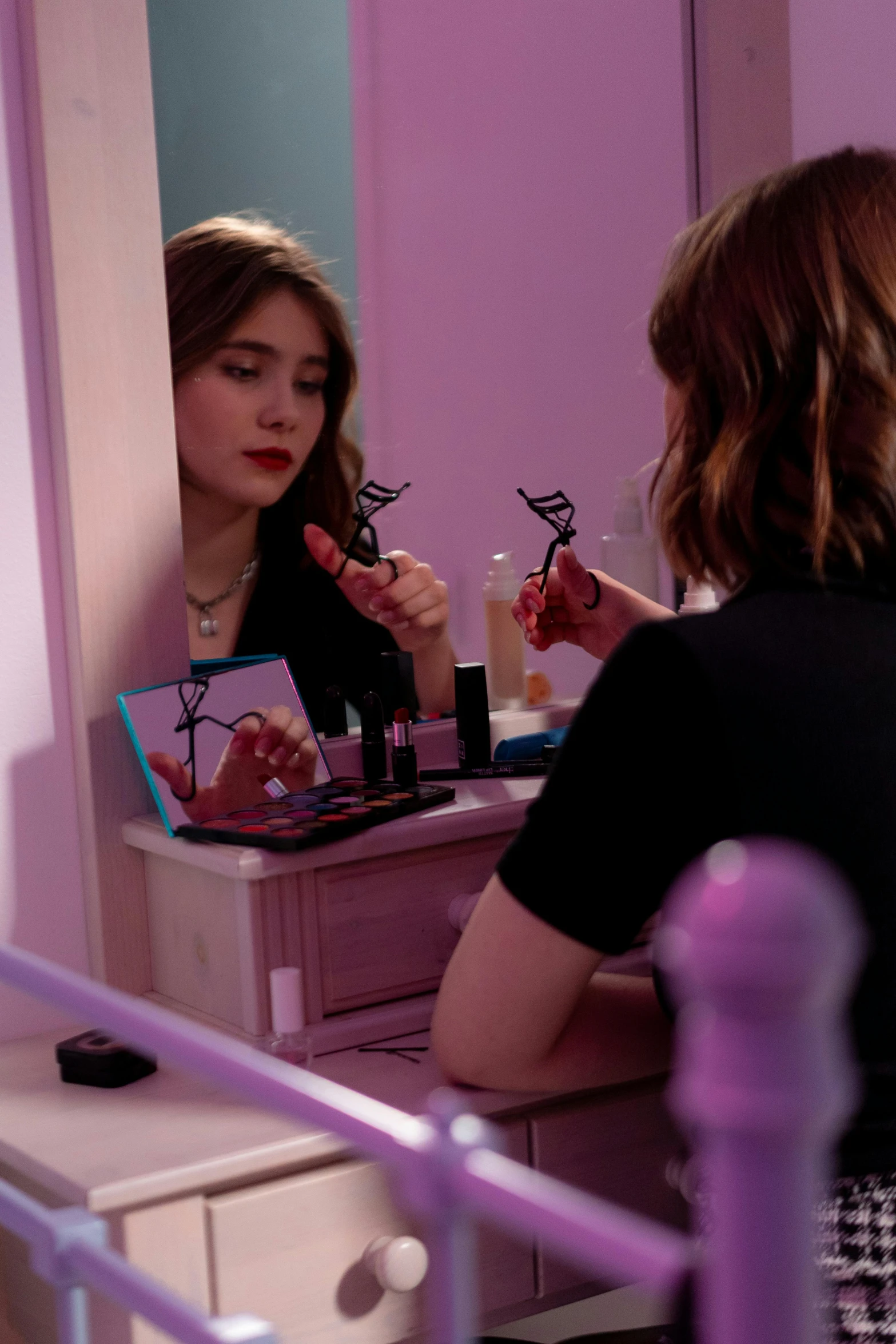 a woman that is sitting in front of a mirror, natalia dyer, putting makeup on, [ theatrical ]