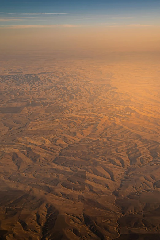 a view of the desert from an airplane, by Daren Bader, middle east, dappled golden sunset, hills, mesopotamic