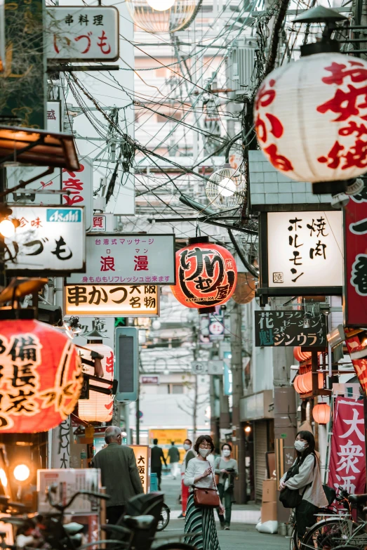 a street filled with lots of different types of signs, inspired by Kanō Hōgai, trending on unsplash, lots of lights, feudal era japan, high-quality photo, masks on wires