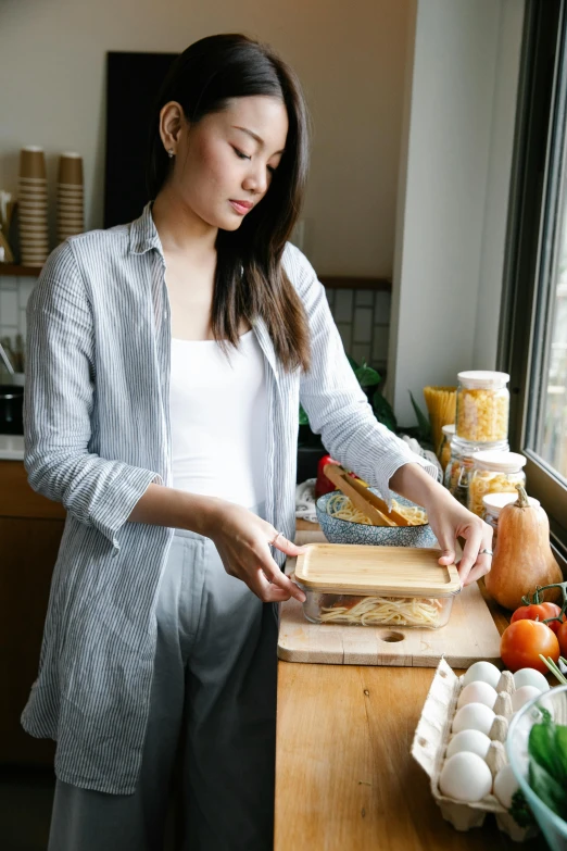 a woman standing in a kitchen preparing food, inspired by Li Di, happening, on a wooden tray, gray, comfortable, full product shot