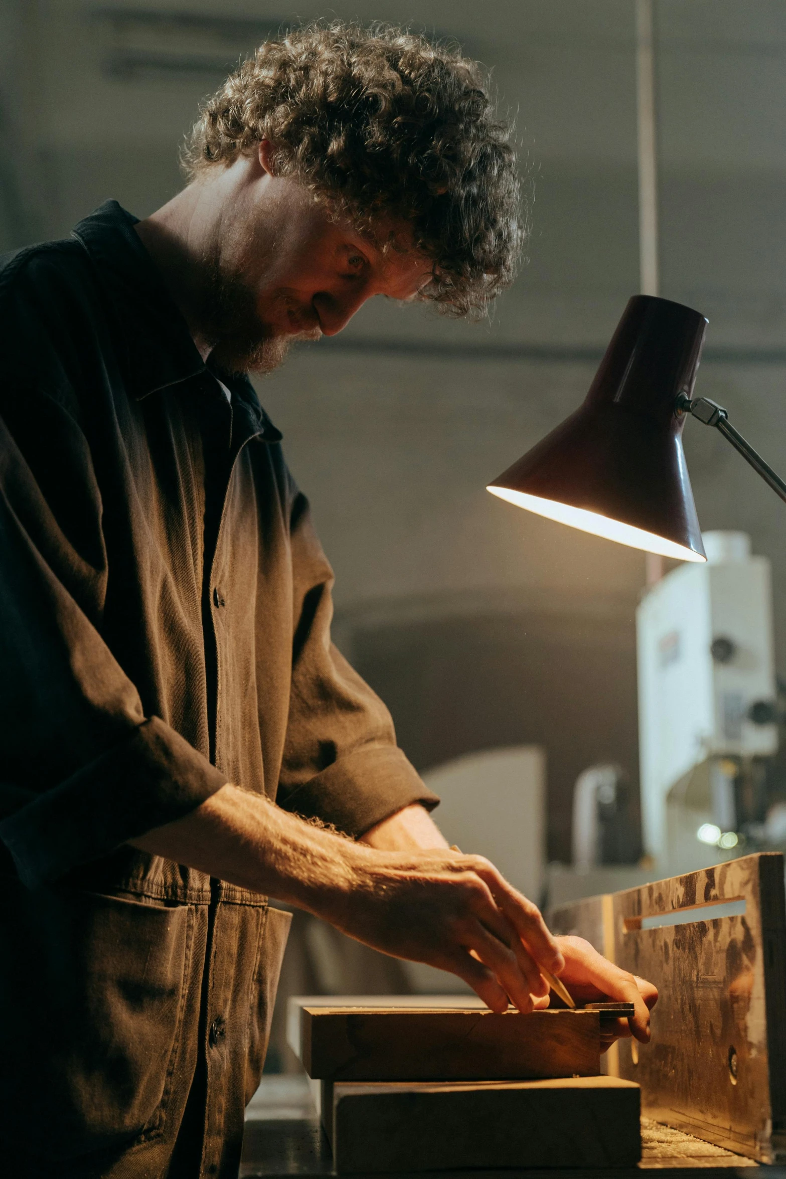 a man working on a piece of wood in a workshop, poster art, by Jan Tengnagel, pexels contest winner, cinematic counter light, australian, made of polished broze, thumbnail