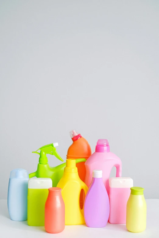 a bunch of bottles sitting on top of a table, a picture, plasticien, on a gray background, sprays, profile image, multicolor